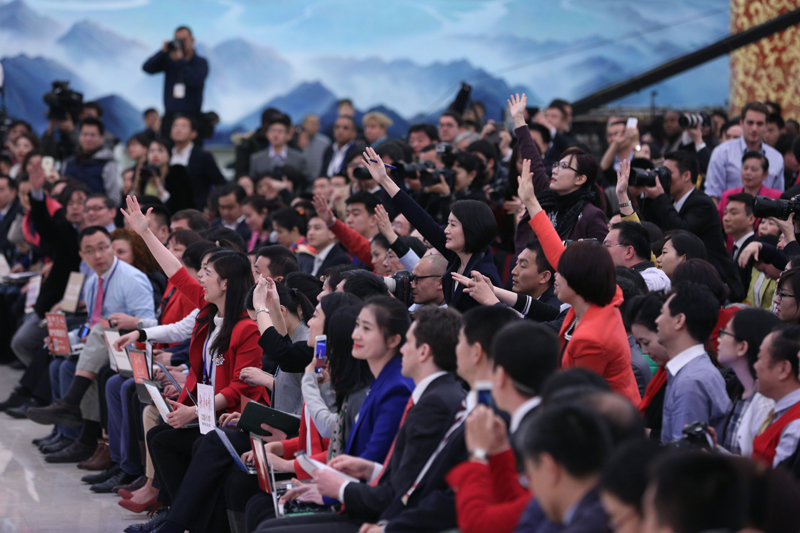 3月15日，國務院總理李克強在北京人民大會堂與中外記者見面，并回答記者提問。這是記者舉手爭取提問機會。 新華社記者 才揚 攝