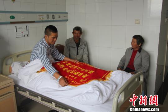 被救的李忠起、張總鳳夫婦看望受傷后的李運(yùn)飛。　汪渝 攝