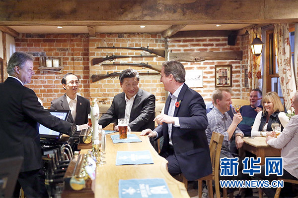 這是會晤結束后，習近平在卡梅倫陪同下乘車前往當地小鎮(zhèn)體驗酒吧文化。新華社記者 鞠鵬 攝